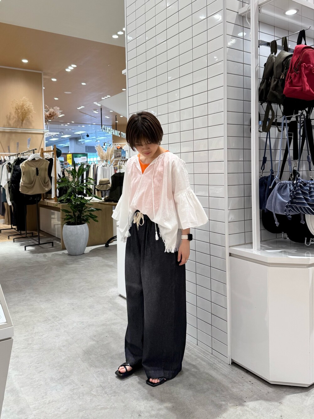 ホワイト系のシャツ/ブラウス、オレンジ系のタンクトップ、ブラック系のデニムパンツを着用したレディースの夏コーディネートの3枚目の写真