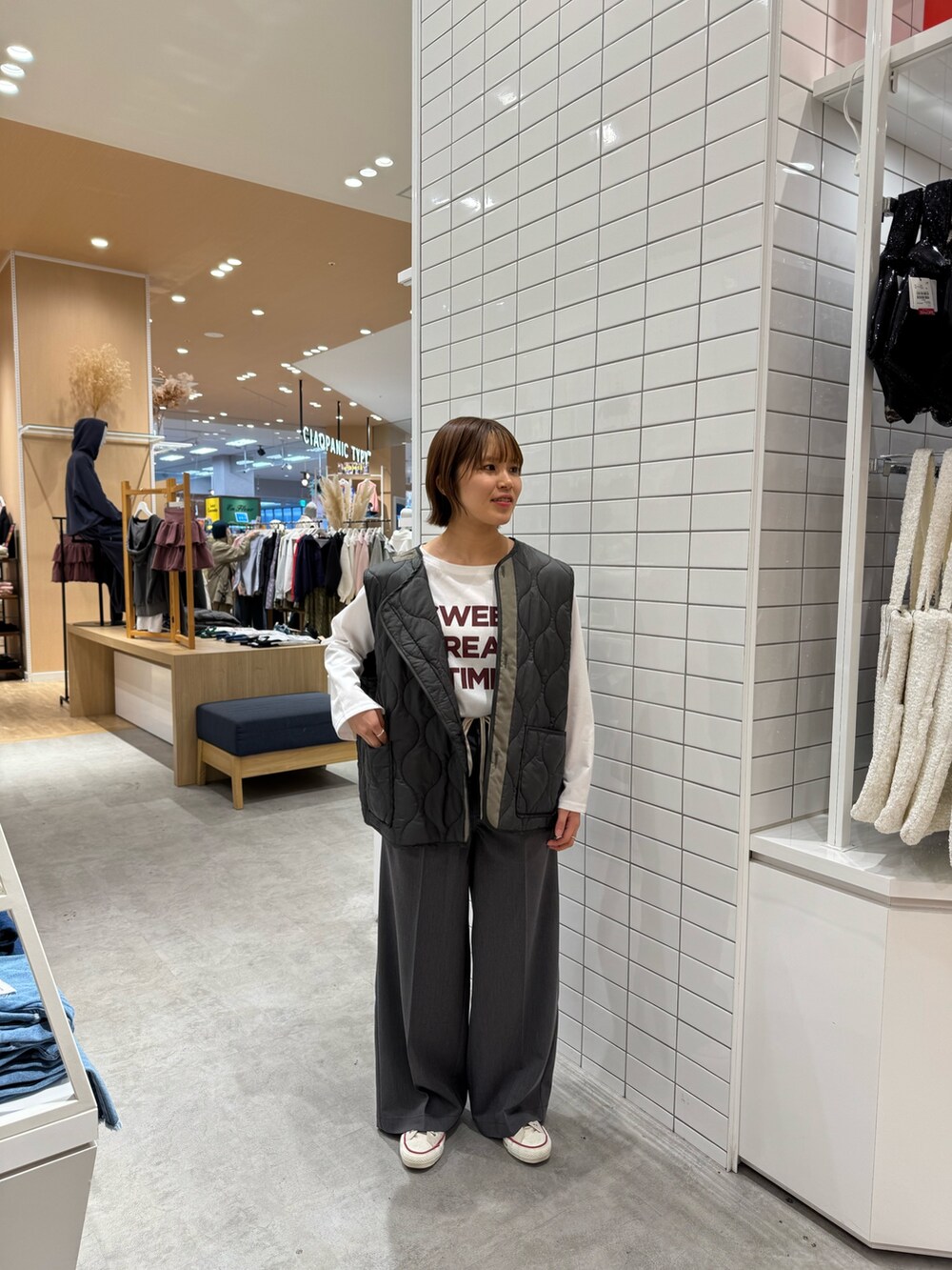 グリーン系のモッズコート、ホワイト系のTシャツ/カットソー、グレー系のパンツを着用したレディースの春コーディネートの3枚目の写真