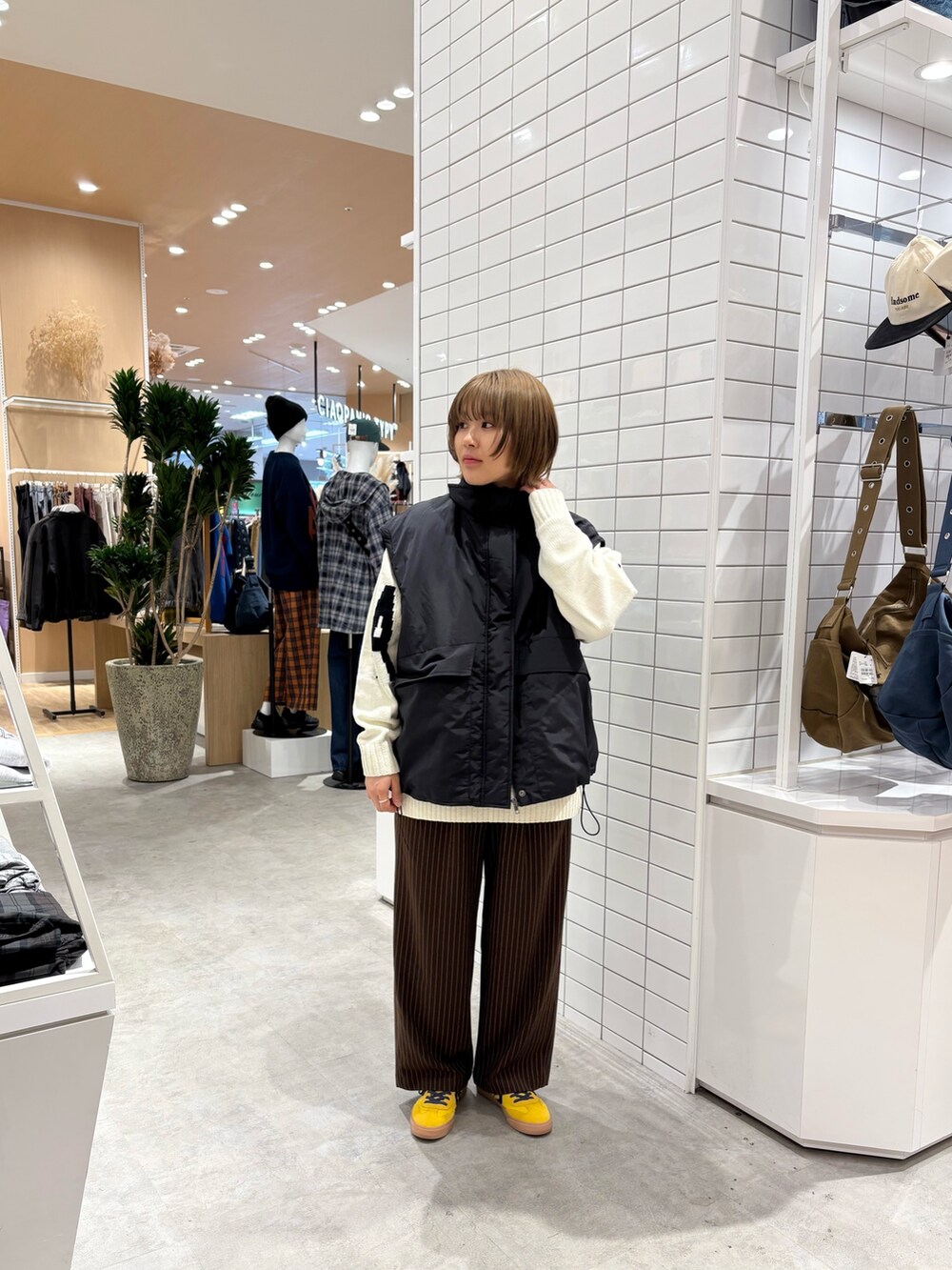 ホワイト系のニット/セーター、ブラウン系のスラックス、ブラック系のブルゾンを着用したレディースの秋コーディネートの2枚目の写真