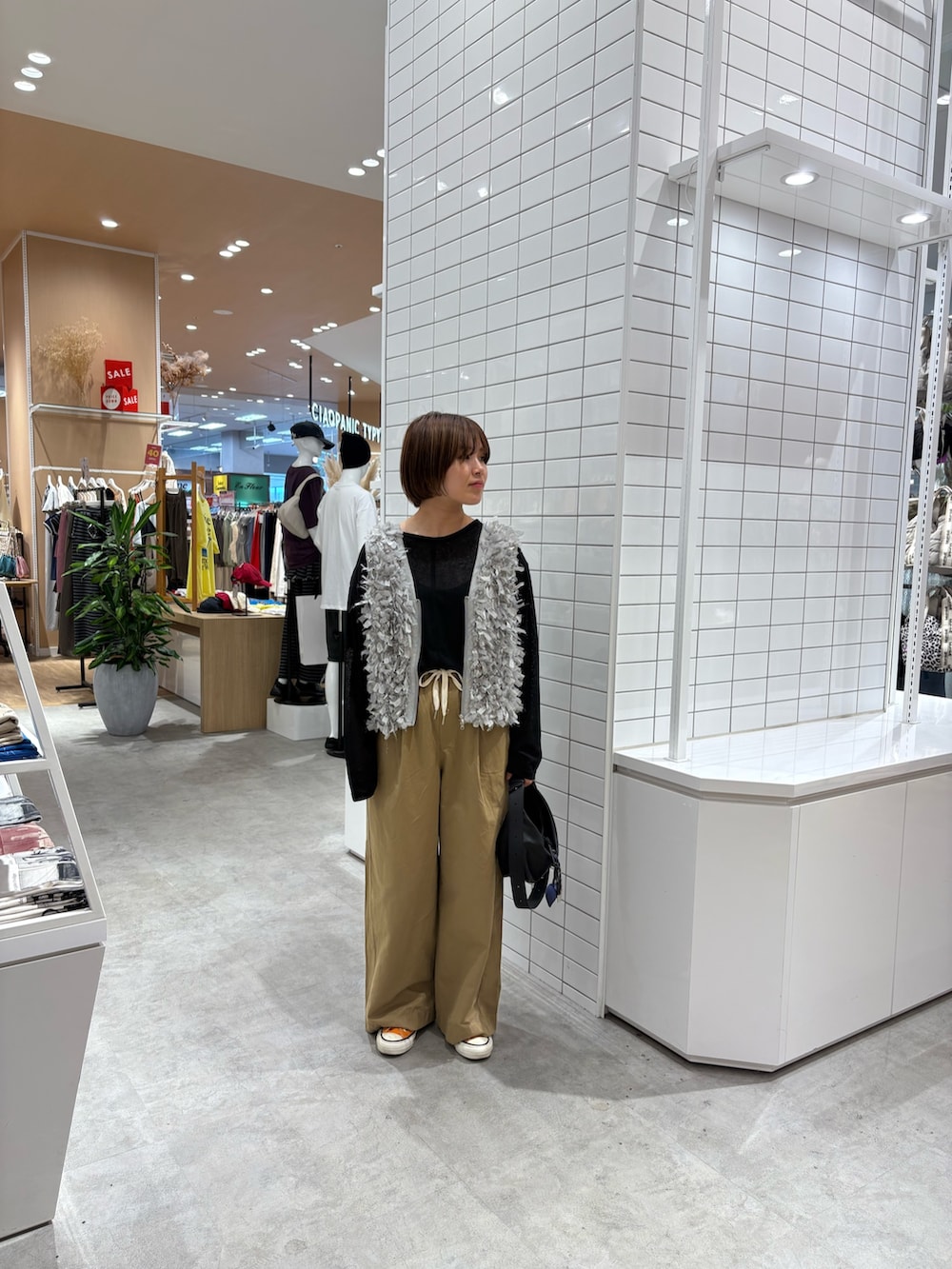 ブラック系のTシャツ/カットソー、グレー系のベスト、ベージュ系のデニムパンツを着用したレディースの秋コーディネートの4枚目の写真