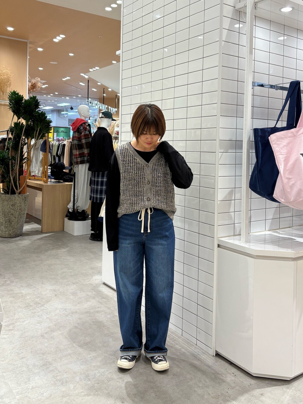 ブルー系のデニムパンツ、グレー系のニット/セーター、ブラック系のTシャツ/カットソーを着用したレディースの秋コーディネートの3枚目の写真