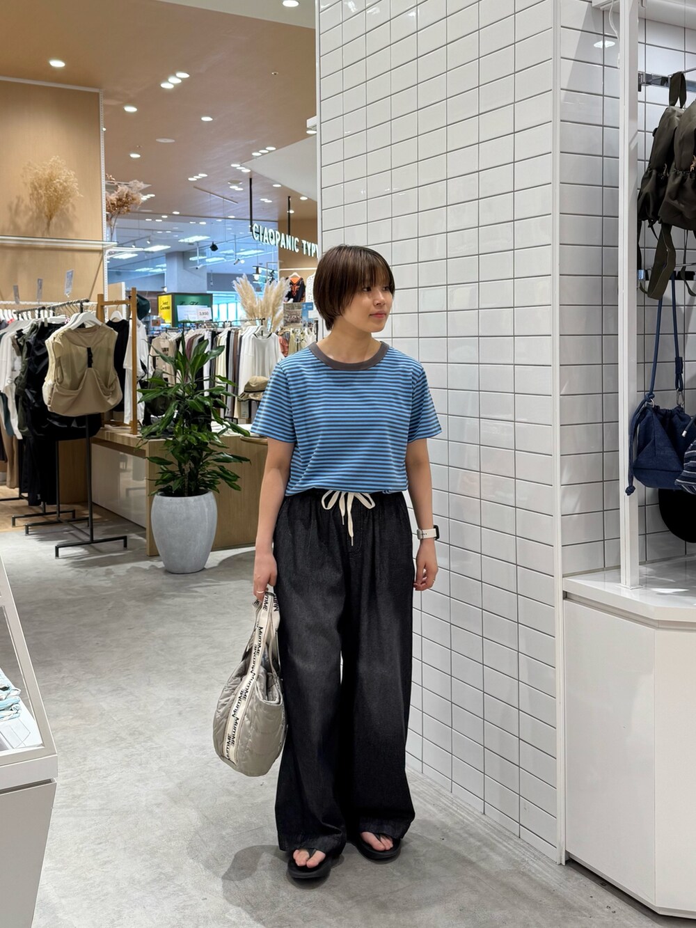 ブルー系のTシャツ/カットソー、ブラック系のデニムパンツ、グレー系のトートバッグを着用したレディースの夏コーディネートの3枚目の写真