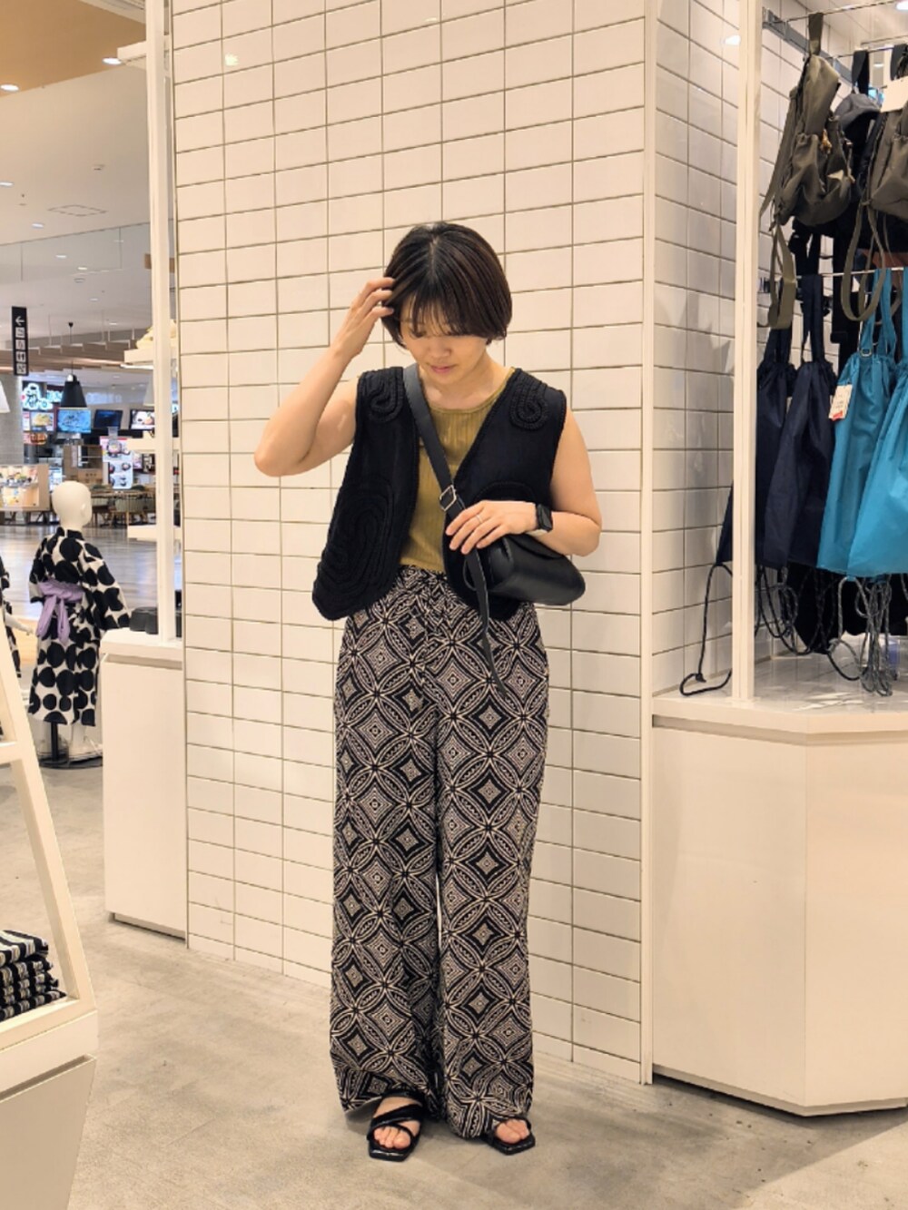 ブラック系のその他パンツ、ブラック系のショルダーバッグ、ブラック系のベストを着用したレディースの夏コーディネートの2枚目の写真