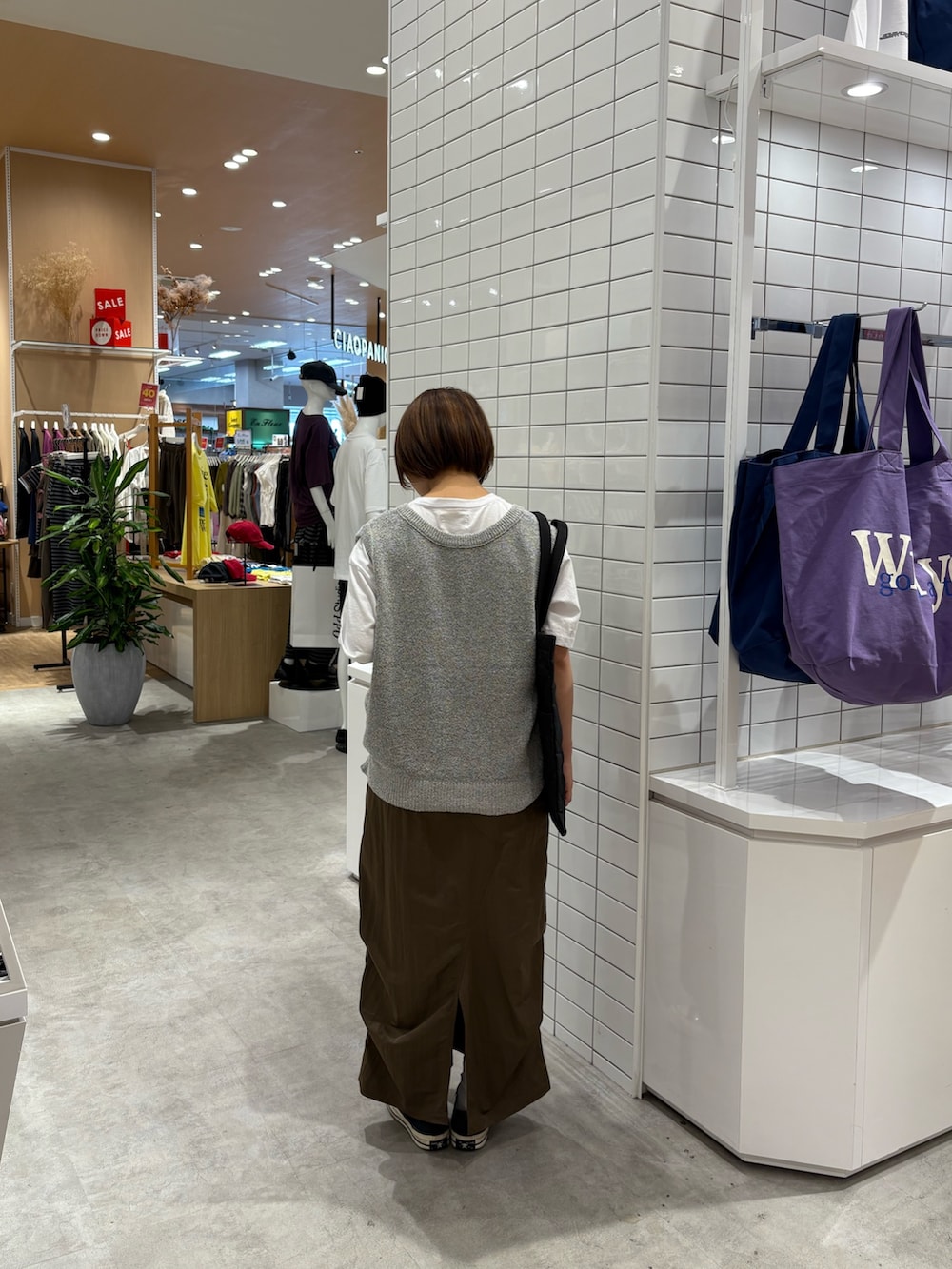 ブラウン系のスカート、ホワイト系のベスト、ホワイト系のTシャツ/カットソーを着用したレディースの秋コーディネートの4枚目の写真