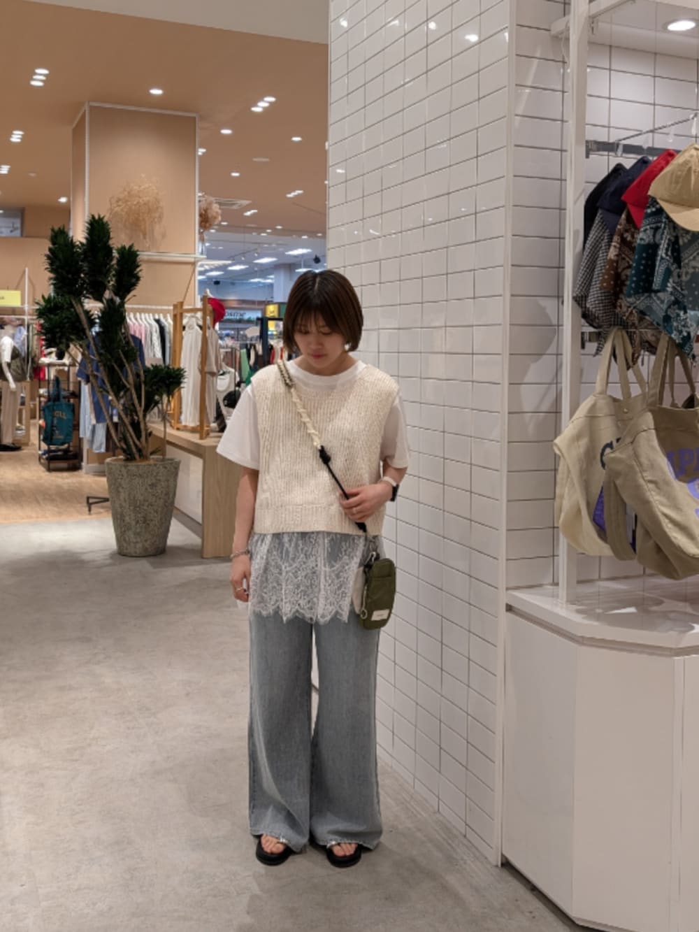 ホワイト系のベスト、ホワイト系のTシャツ/カットソー、ブルー系のデニムパンツを着用したレディースの夏コーディネートの3枚目の写真