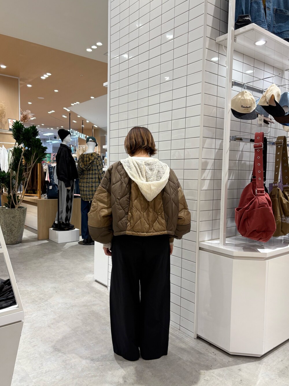 ブラック系のデニムパンツ、イエロー系のブルゾン、ホワイト系のTシャツ/カットソーを着用したレディースの秋コーディネートの4枚目の写真