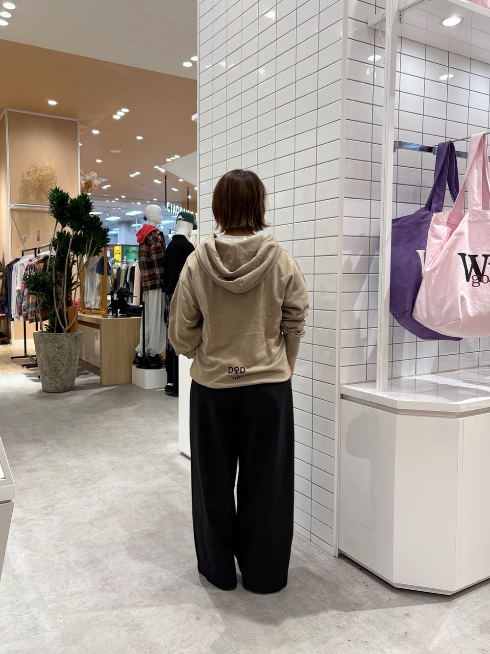 ベージュ系のパーカー、ブラック系のデニムパンツ、ブラック系のトートバッグを着用したレディースの秋コーディネートの4枚目の写真