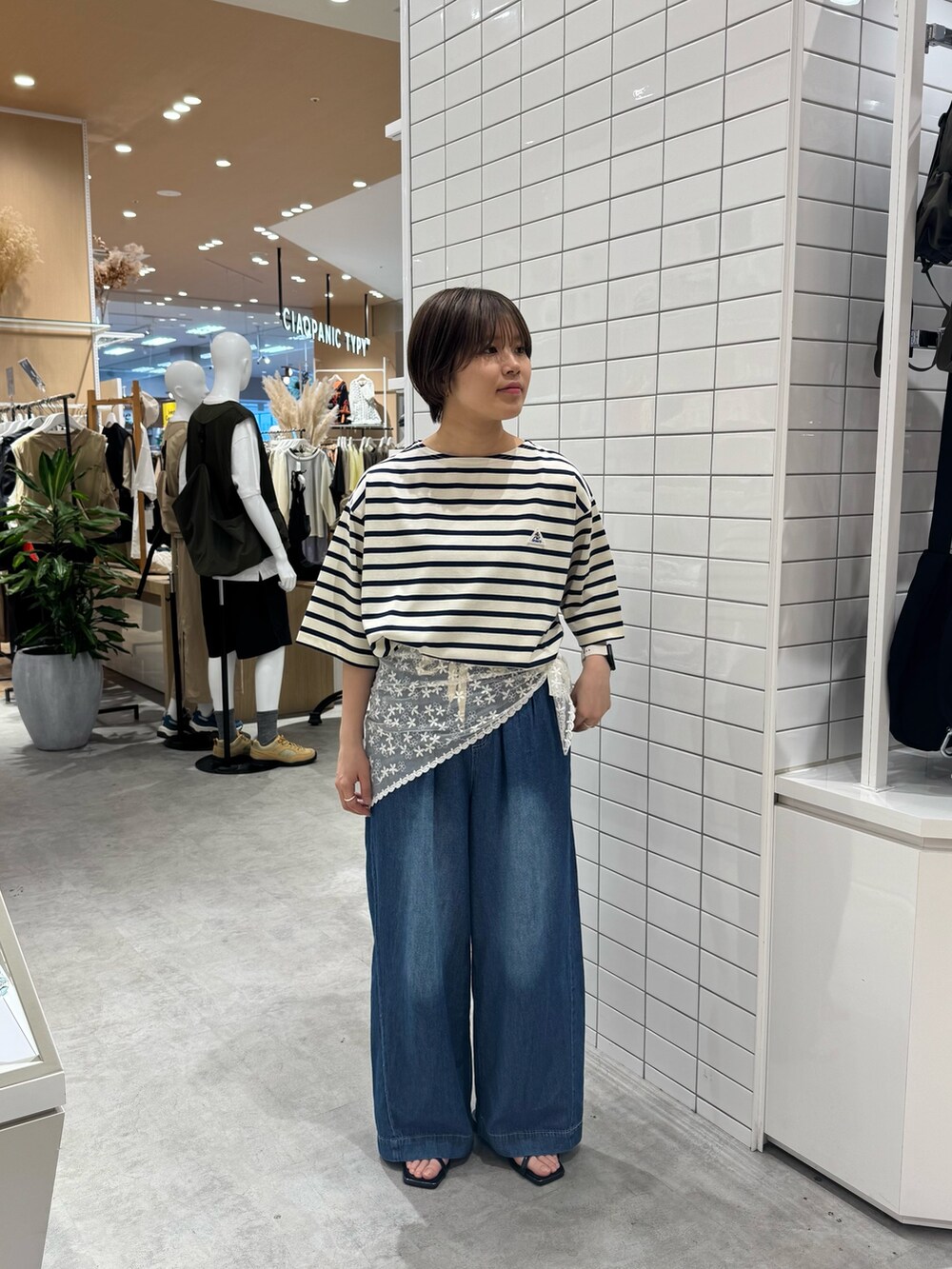 ホワイト系のTシャツ/カットソー、ブルー系のデニムパンツ、ブラック系のサンダルを着用したレディースの夏コーディネートの2枚目の写真