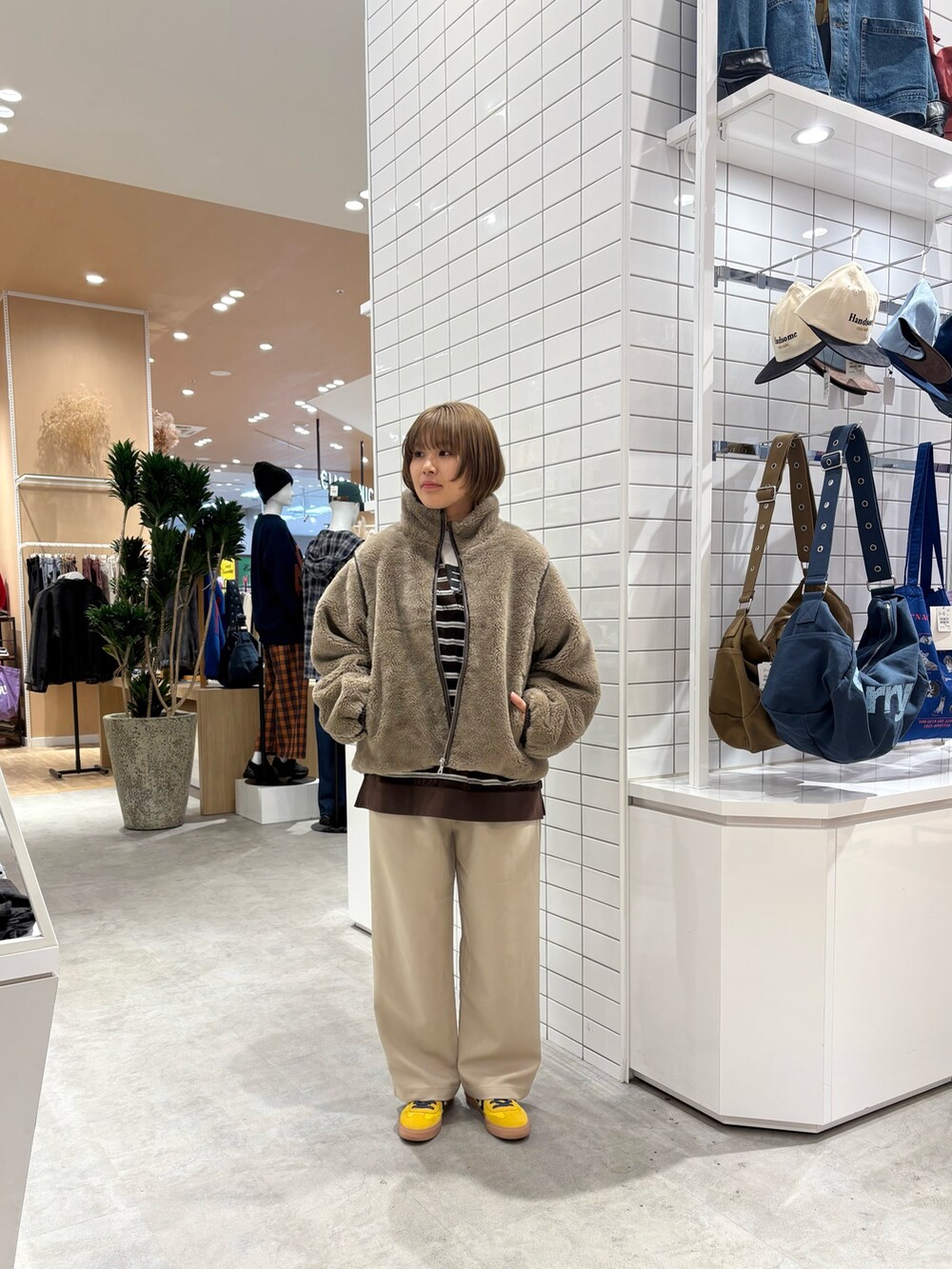 ベージュ系のスラックス、ブラウン系のTシャツ/カットソー、ベージュ系のブルゾンを着用したレディースの秋コーディネートの3枚目の写真