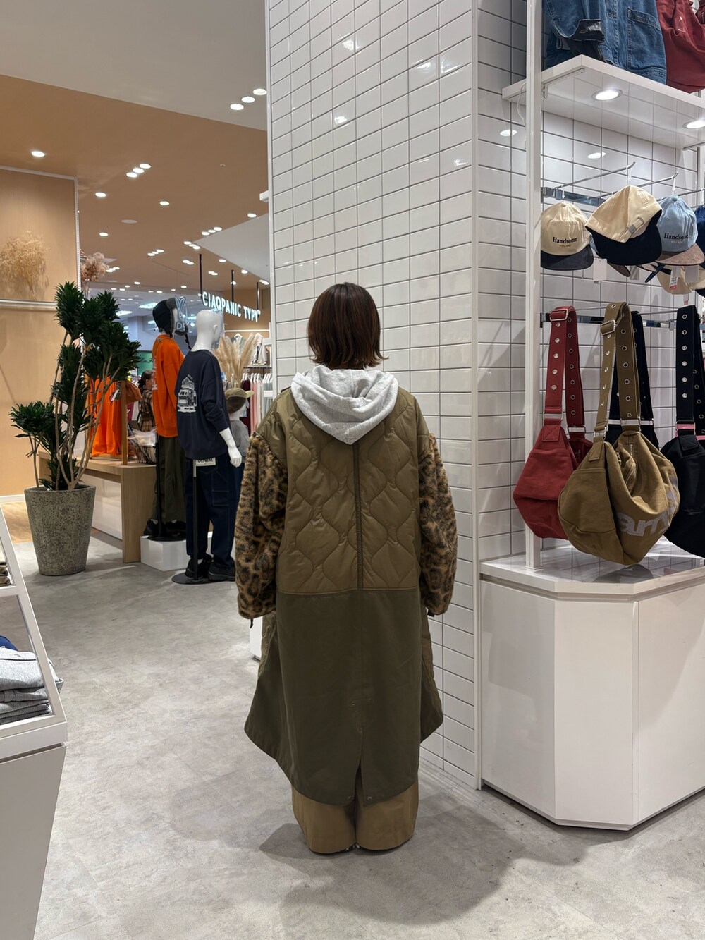 グレー系のパーカー、ベージュ系のデニムパンツ、グリーン系のノーカラーコートを着用したレディースの秋コーディネートの5枚目の写真