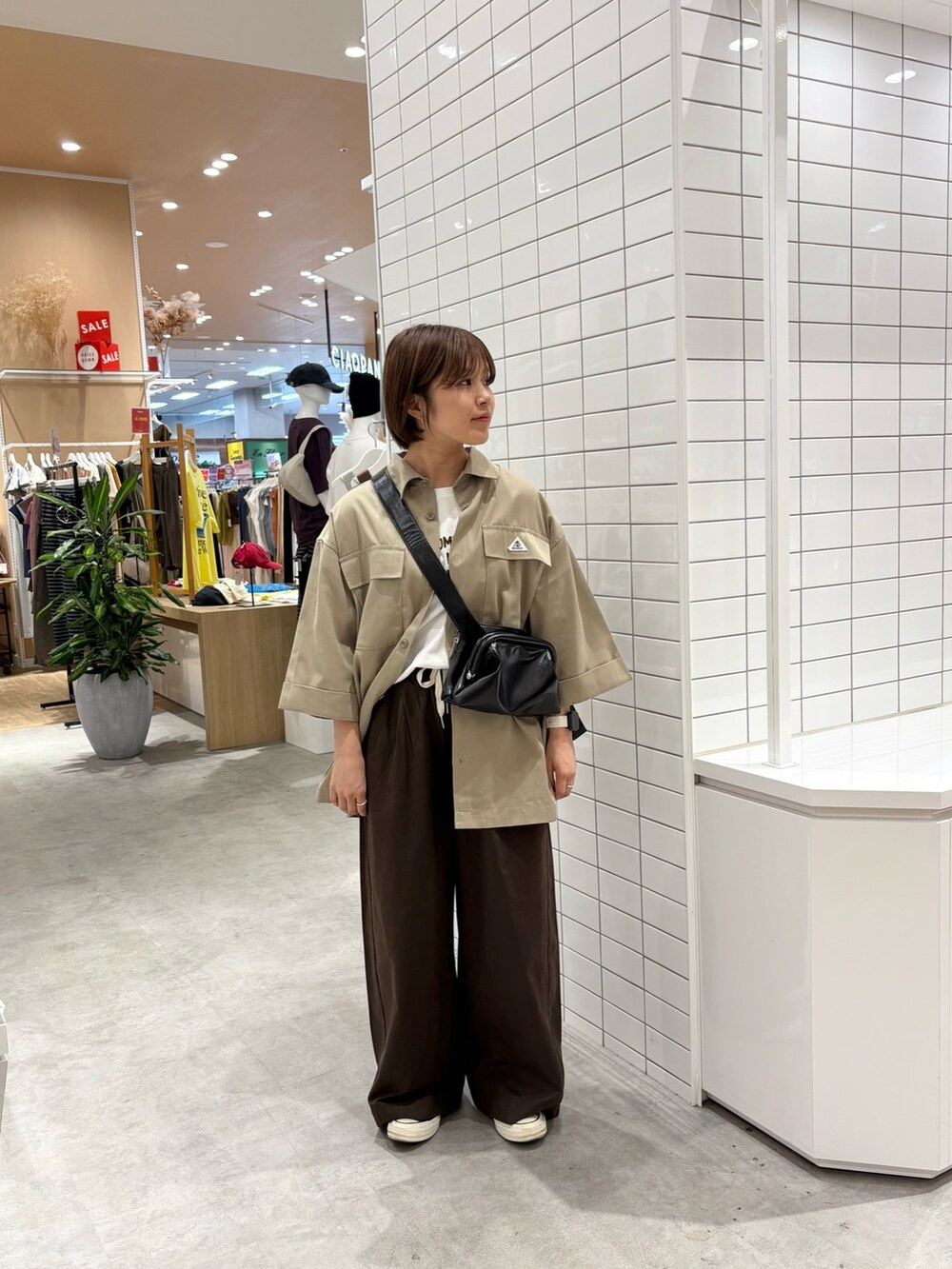 ブラウン系のデニムパンツ、ホワイト系のTシャツ/カットソー、ベージュ系のシャツ/ブラウスを着用したレディースの秋コーディネートの2枚目の写真