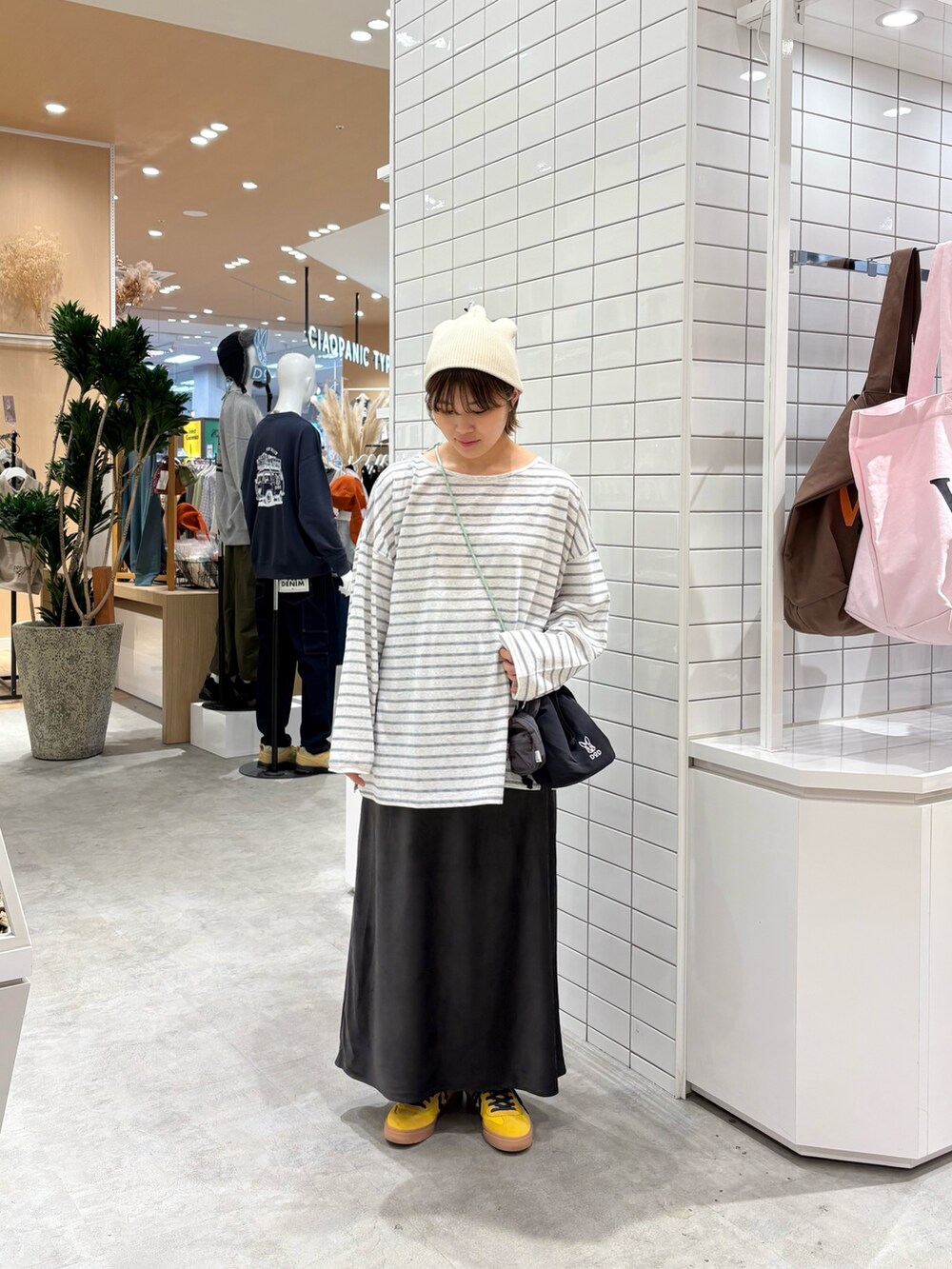 グレー系のTシャツ/カットソー、ブラック系のトートバッグ、グレー系のスカートを着用したレディースの秋コーディネートの3枚目の写真