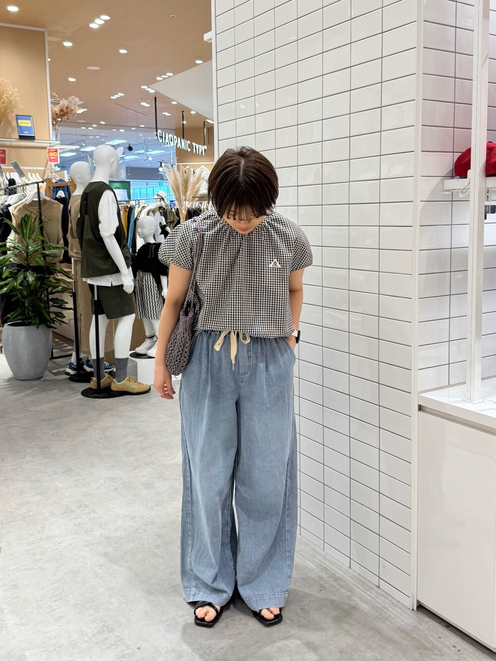 ブラック系のシャツ/ブラウス、ブルー系のデニムパンツ、ブラック系のサンダルを着用したレディースの夏コーディネートの3枚目の写真