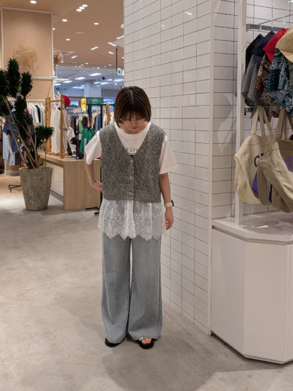 ホワイト系のTシャツ/カットソー、グレー系のベスト、ブルー系のデニムパンツを着用したレディースの夏コーディネートの2枚目の写真