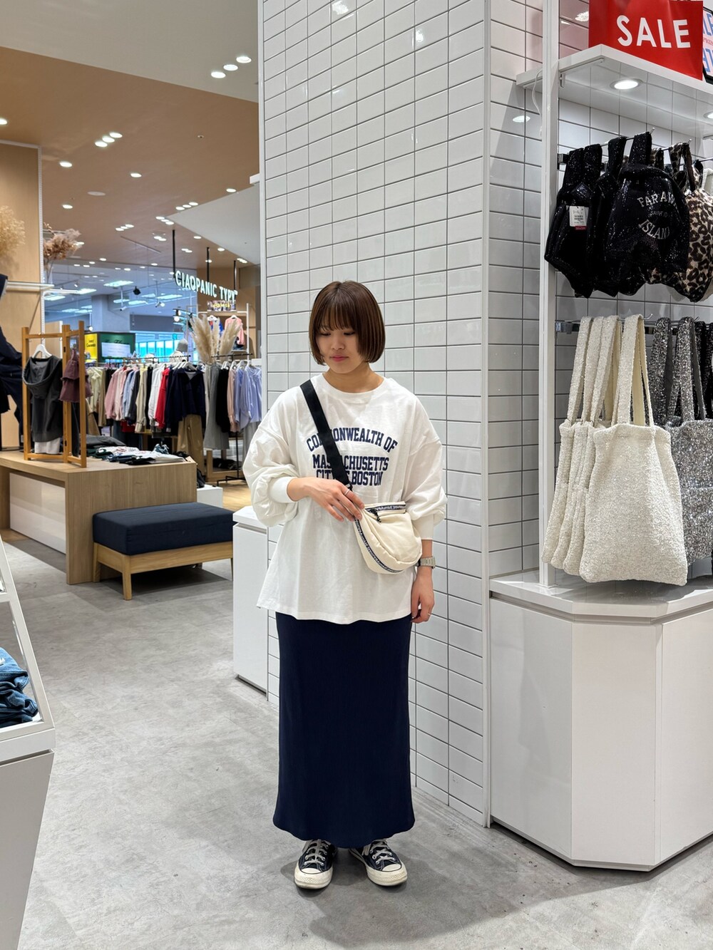 ホワイト系のTシャツ/カットソー、ホワイト系のショルダーバッグ、ブルー系のスカートを着用したレディースの春コーディネートの2枚目の写真