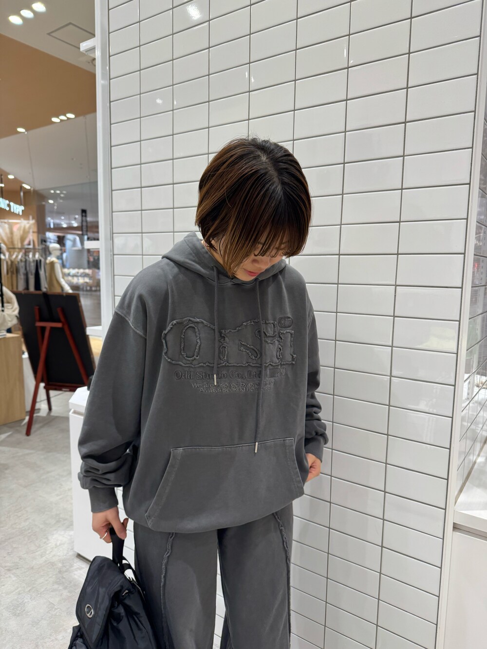 グレー系のその他パンツ、グレー系のパーカー、ブラック系のバックパック/リュックを着用したレディースの春コーディネートの4枚目の写真