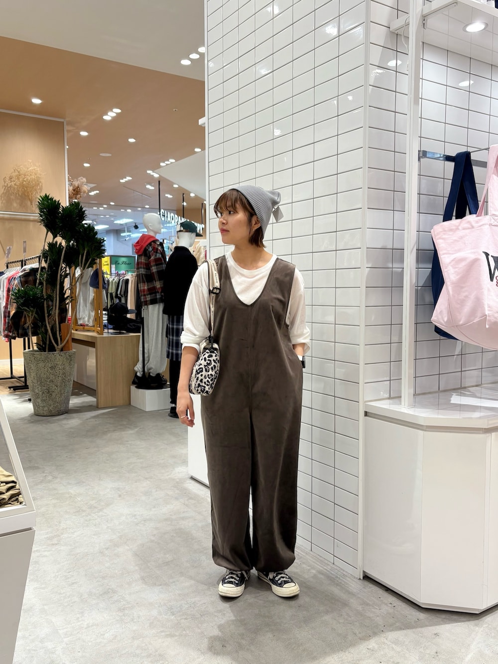 ホワイト系のショルダーバッグ、ホワイト系のTシャツ/カットソー、ブラウン系のつなぎ/オールインワンを着用したレディースの秋コーディネートの3枚目の写真