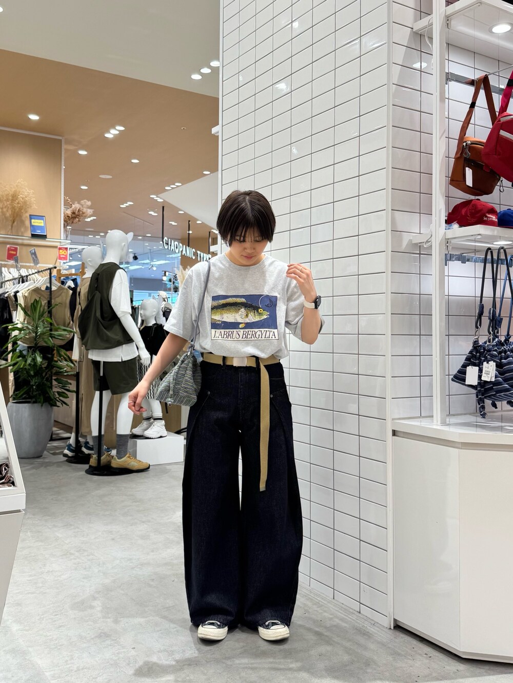 グレー系のTシャツ/カットソー、ブラック系のデニムパンツ、グリーン系のショルダーバッグを着用したレディースの夏コーディネートの2枚目の写真