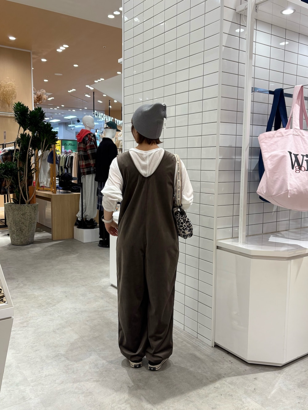 ホワイト系のショルダーバッグ、ホワイト系のTシャツ/カットソー、ブラウン系のつなぎ/オールインワンを着用したレディースの秋コーディネートの4枚目の写真