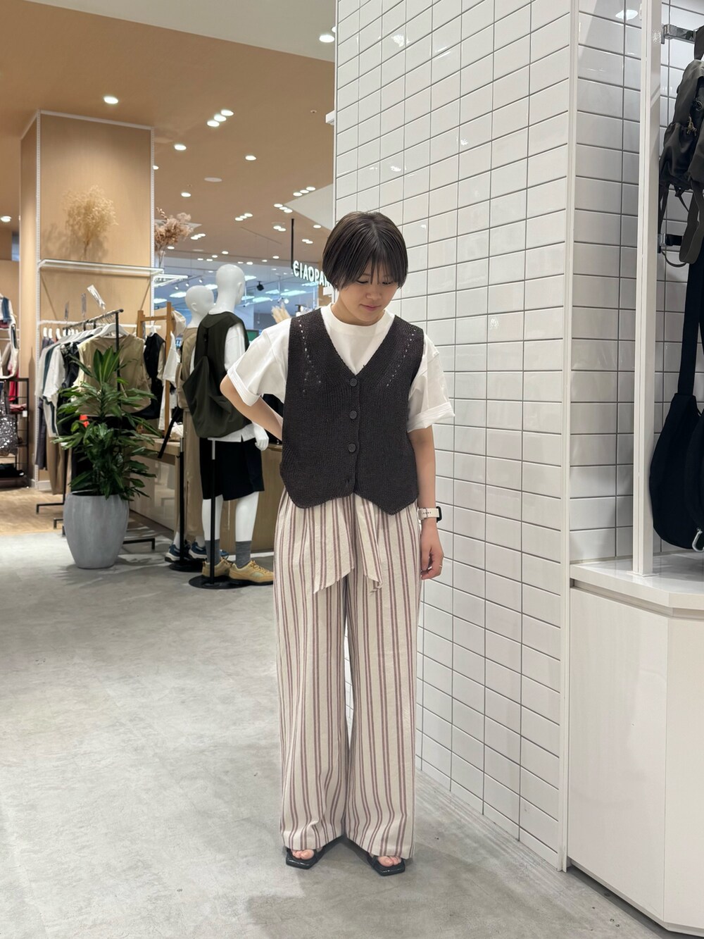 ブラウン系のベスト、ホワイト系のその他パンツ、ホワイト系のTシャツ/カットソーを着用したレディースの夏コーディネートの3枚目の写真