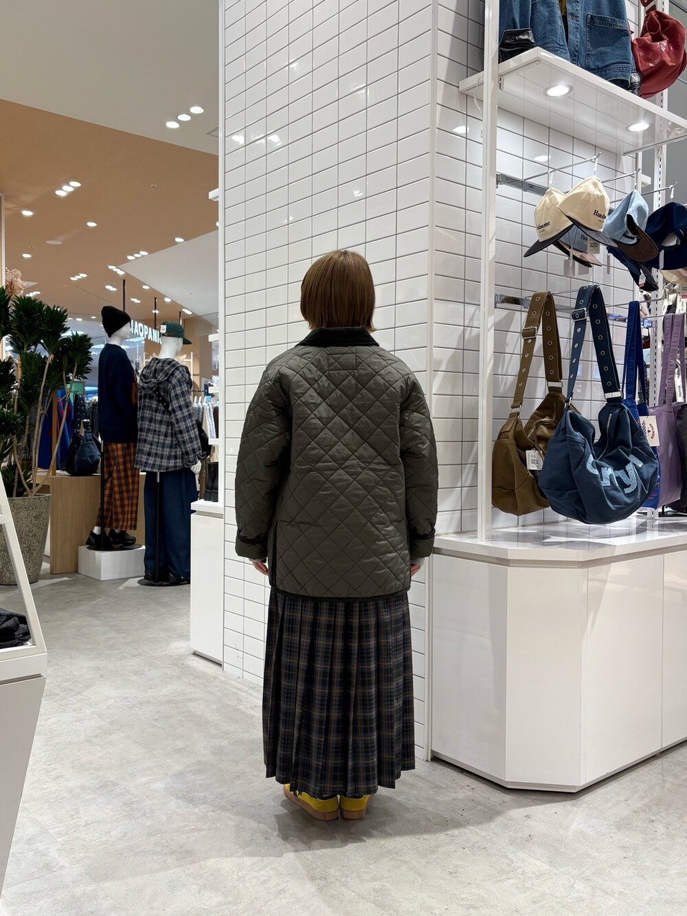 グリーン系のブルゾン、グレー系のスウェット、グレー系のスカートを着用したレディースの秋コーディネートの5枚目の写真