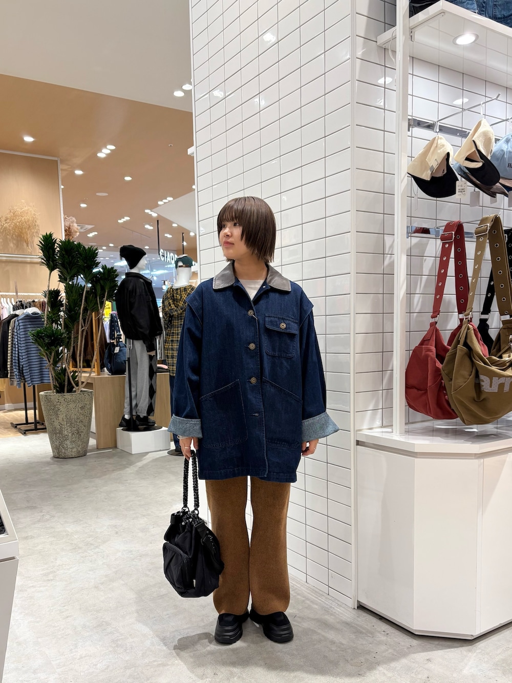 ブルー系のその他アウター、ブラウン系のその他パンツ、ブラック系のトートバッグを着用したレディースの秋コーディネートの3枚目の写真