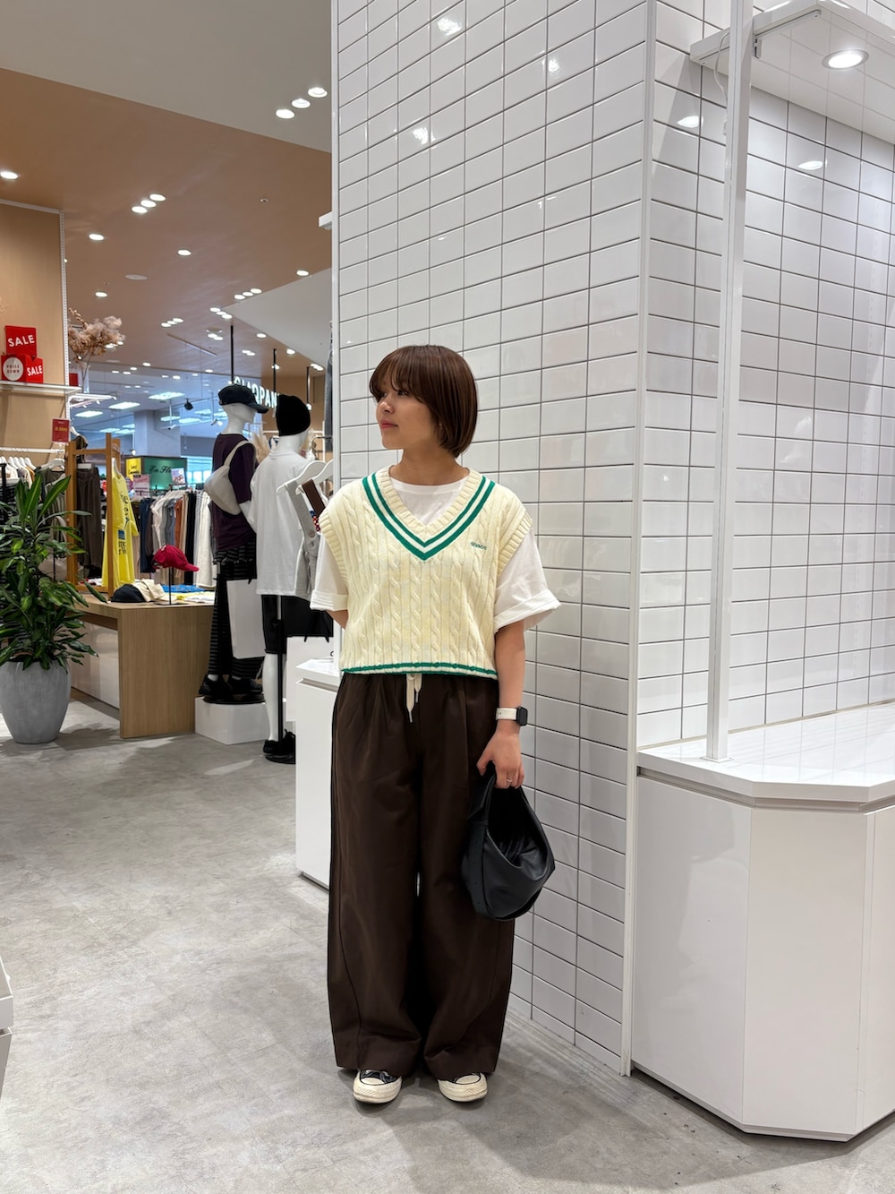 ホワイト系のTシャツ/カットソー、ホワイト系のベスト、ブラウン系のデニムパンツを着用したレディースの秋コーディネートの3枚目の写真