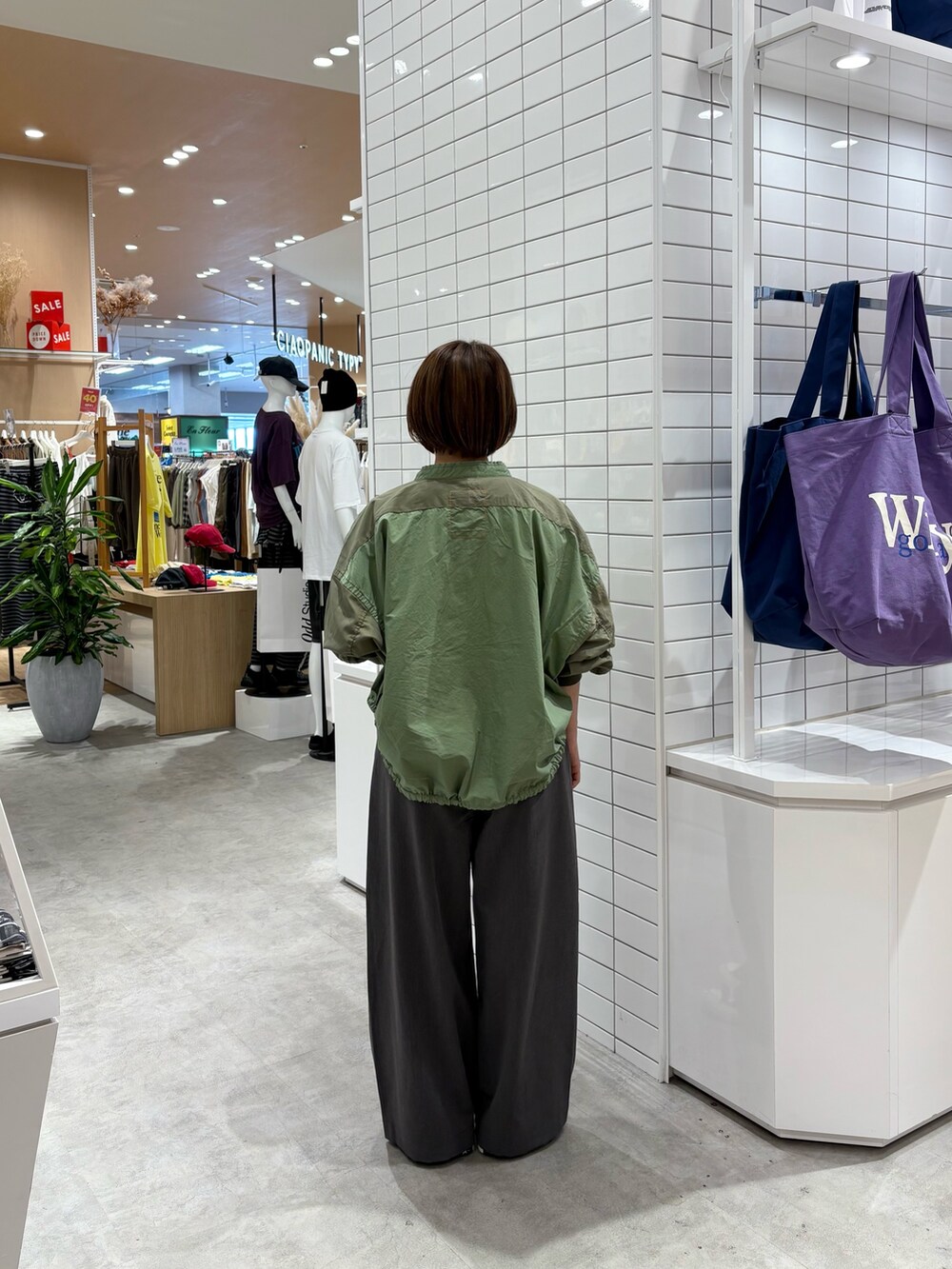 グレー系のデニムパンツ、ホワイト系のTシャツ/カットソー、グリーン系のブルゾンを着用したレディースの秋コーディネートの5枚目の写真