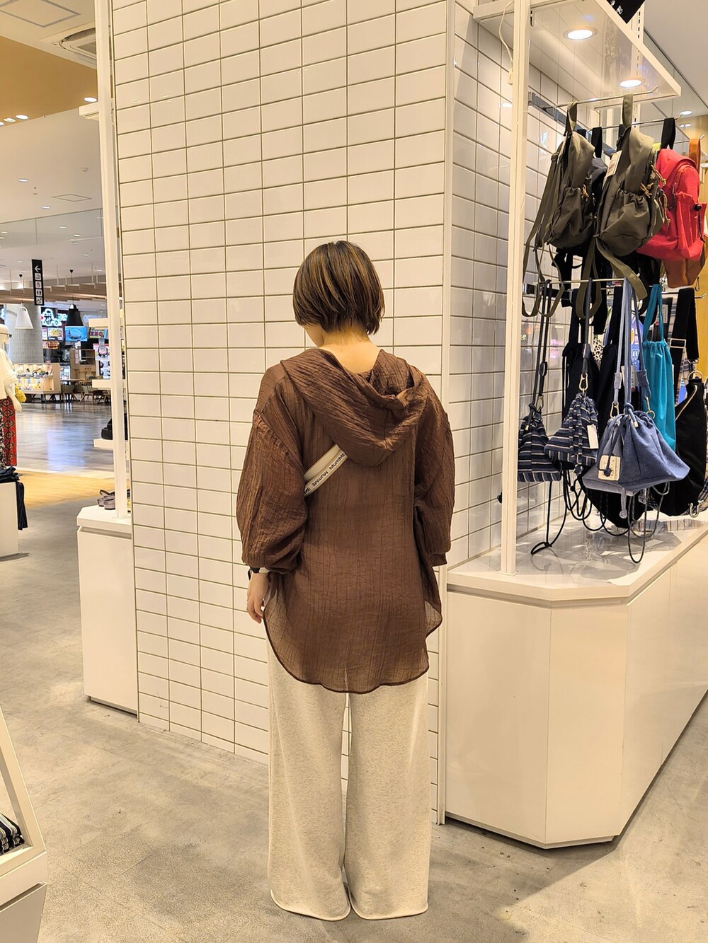 ホワイト系のスウェットパンツ、ホワイト系のショルダーバッグ、グレー系のタンクトップを着用したレディースの夏コーディネートの4枚目の写真