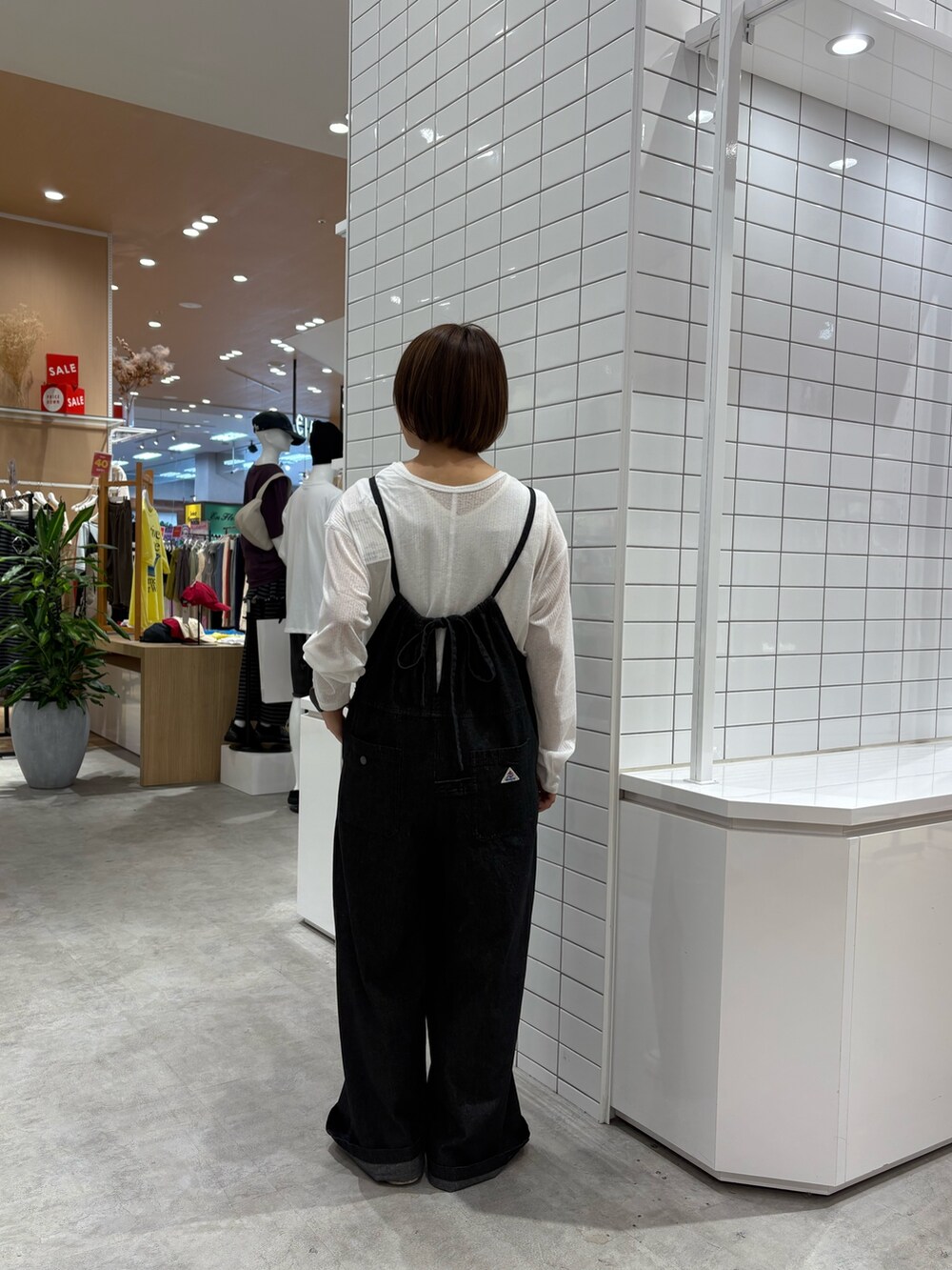 ブラック系のサロペット/オーバーオール、ホワイト系のTシャツ/カットソーを着用したレディースの秋コーディネートの4枚目の写真