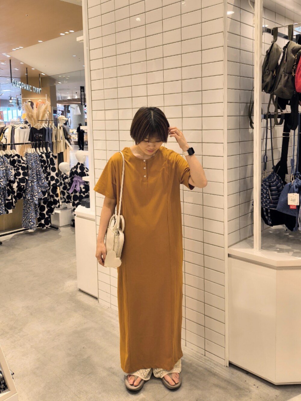 イエロー系のワンピース、ホワイト系のその他パンツ、ホワイト系のトートバッグを着用したレディースの夏コーディネートの2枚目の写真