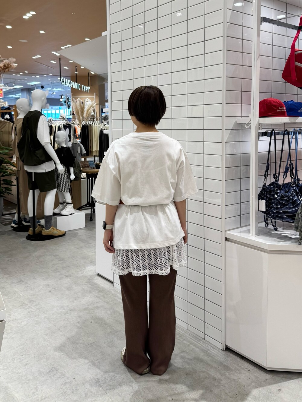 ホワイト系のTシャツ/カットソー、オレンジ系のボディバッグ/ウエストポーチ、ホワイト系のキャミソールを着用したレディースの春コーディネートの4枚目の写真