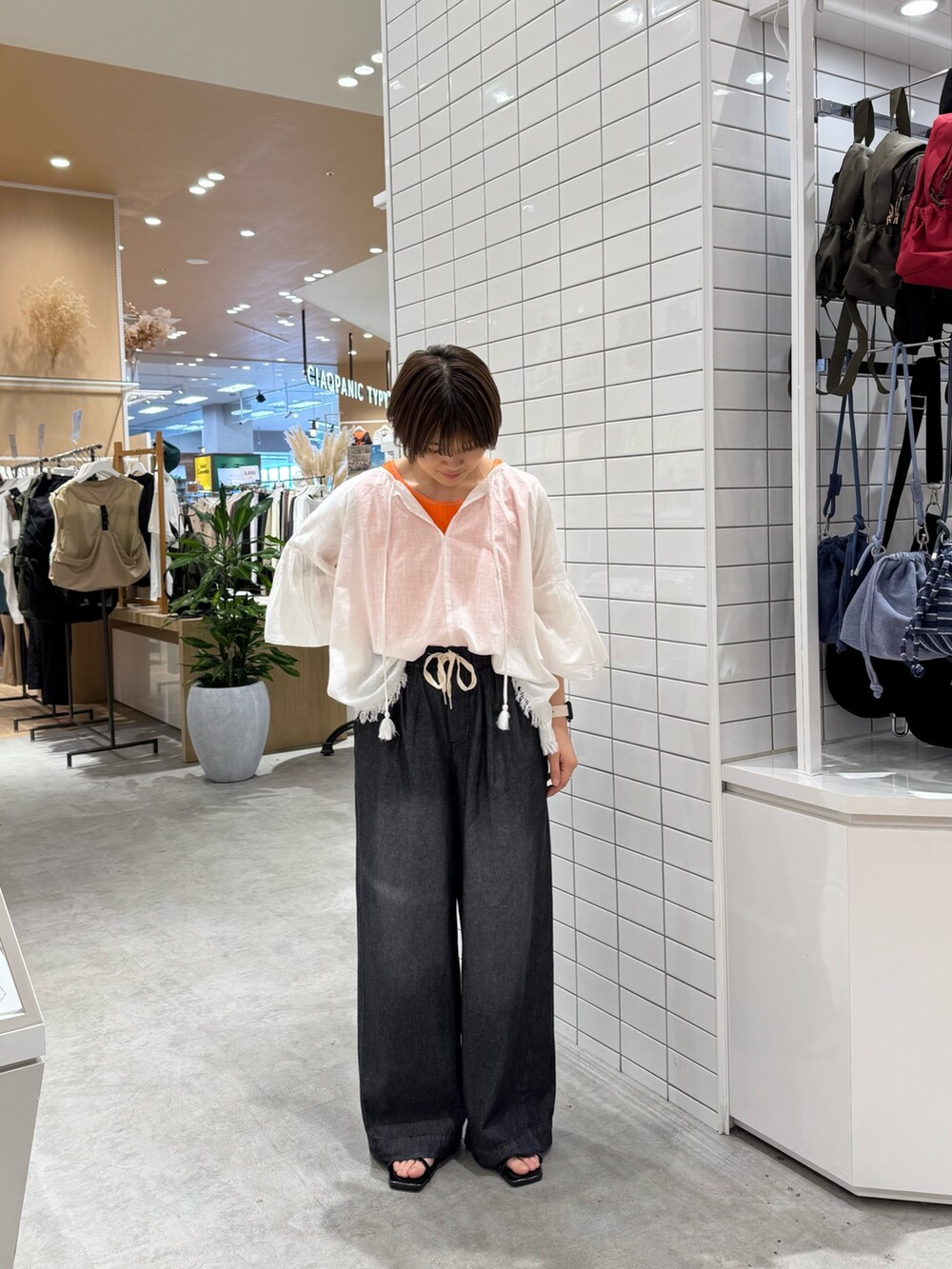 ホワイト系のシャツ/ブラウス、オレンジ系のタンクトップ、ブラック系のデニムパンツを着用したレディースの夏コーディネートの2枚目の写真