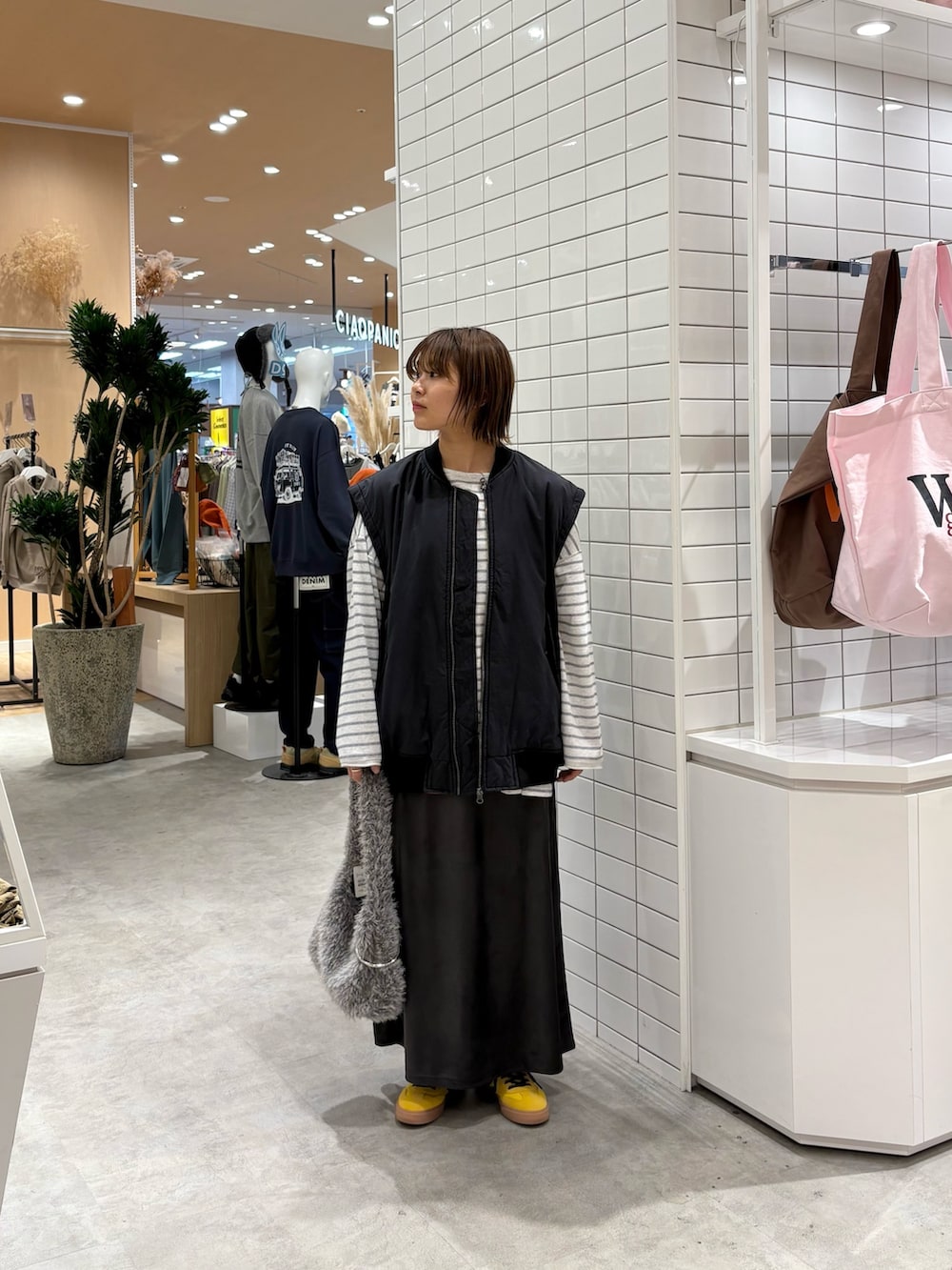 グレー系のスカート、ブラック系のMA-1、グレー系のTシャツ/カットソーを着用したレディースの秋コーディネートの3枚目の写真