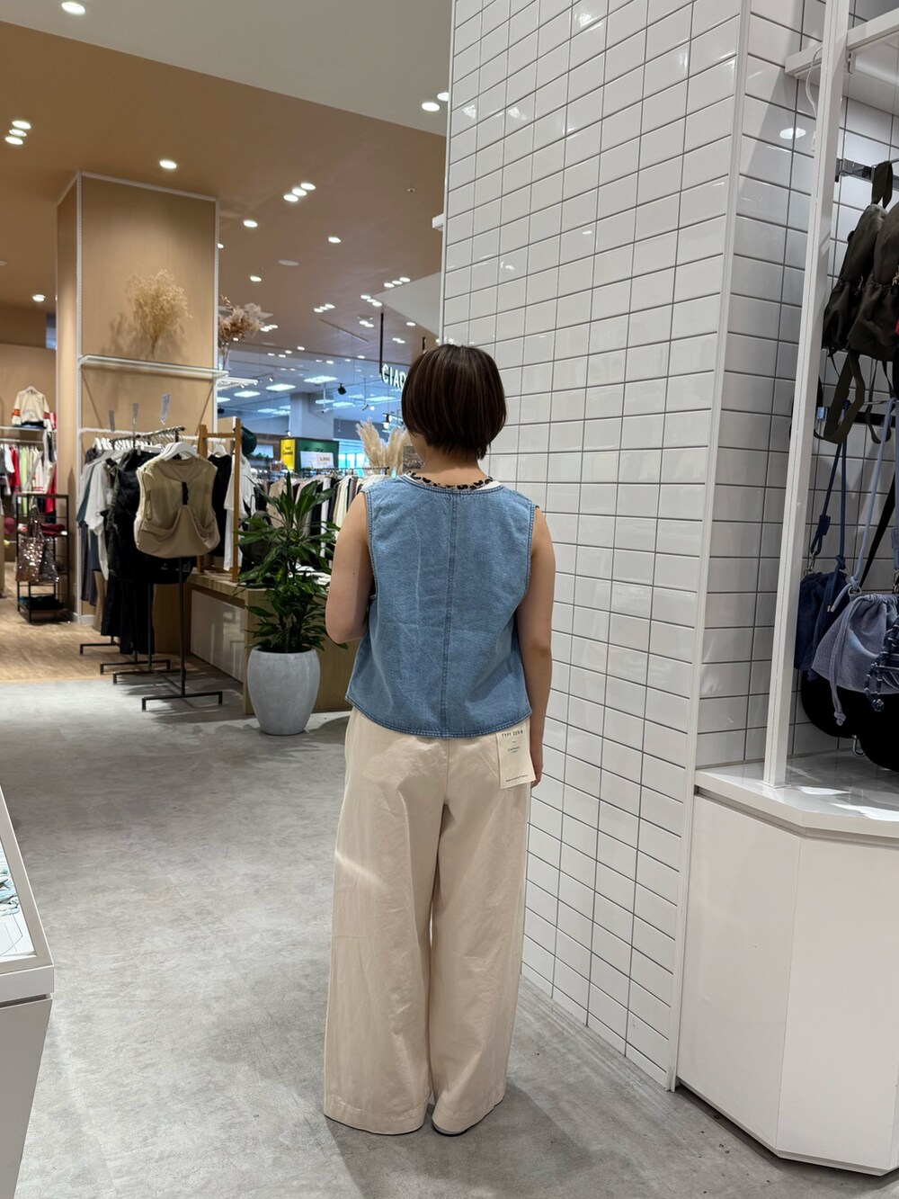 ホワイト系のデニムパンツ、シルバー系のサンダル、ホワイト系のタンクトップを着用したレディースの夏コーディネートの5枚目の写真