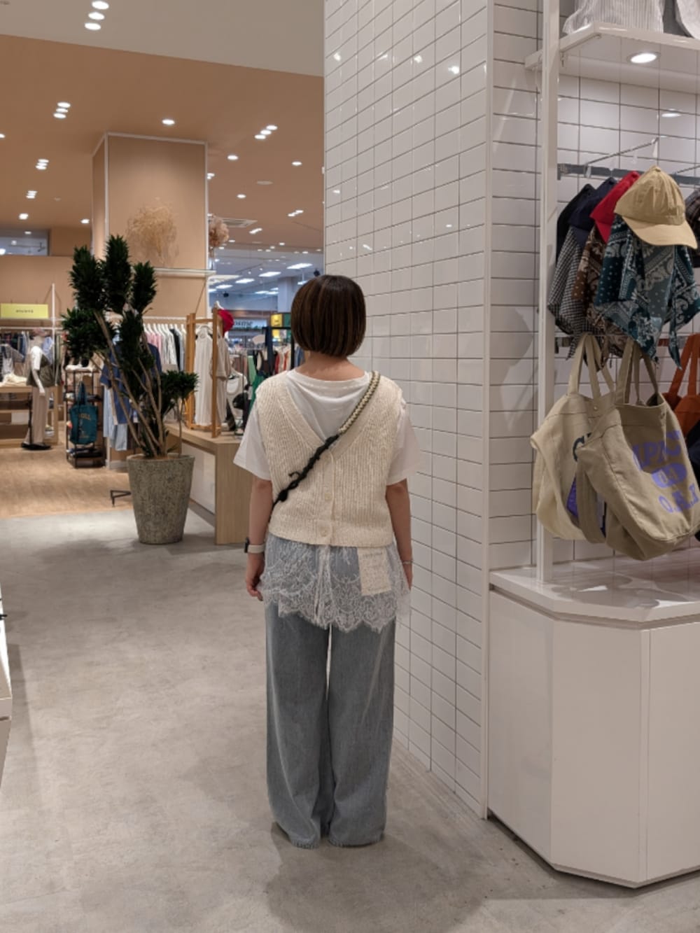 ホワイト系のベスト、ホワイト系のTシャツ/カットソー、ブルー系のデニムパンツを着用したレディースの夏コーディネートの4枚目の写真