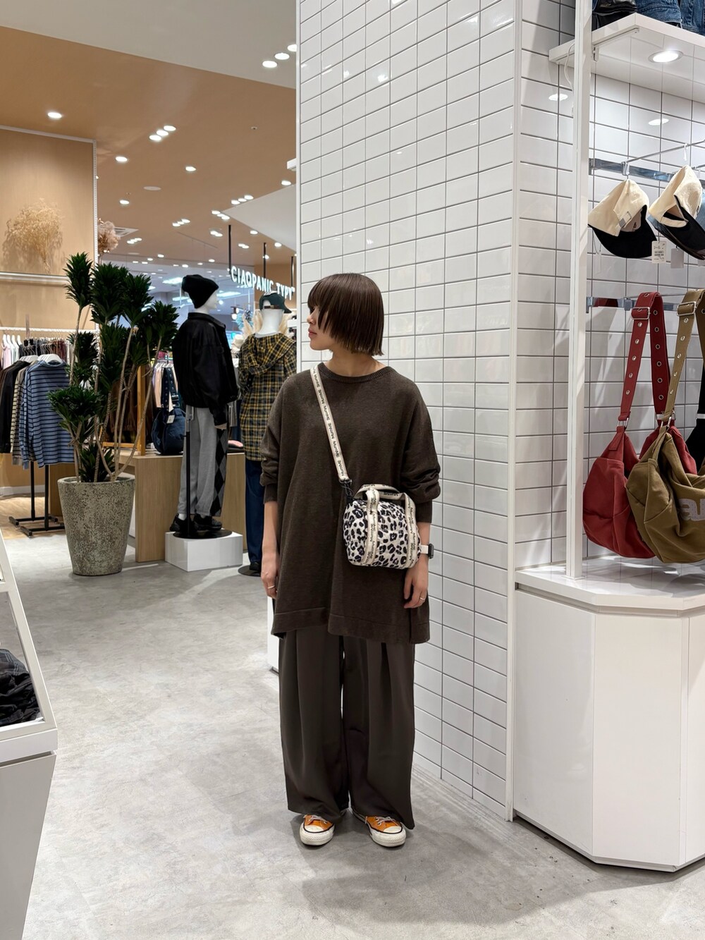 ホワイト系のショルダーバッグ、ブラウン系のニット/セーター、グレー系のその他パンツを着用したレディースの秋コーディネートの3枚目の写真