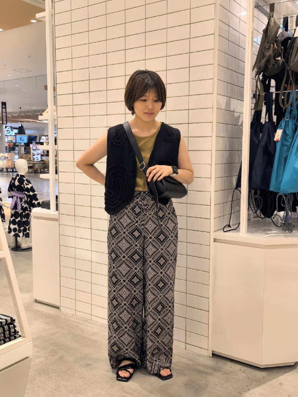 ブラック系のその他パンツ、ブラック系のショルダーバッグ、ブラック系のベストを着用したレディースの夏コーディネートの3枚目の写真