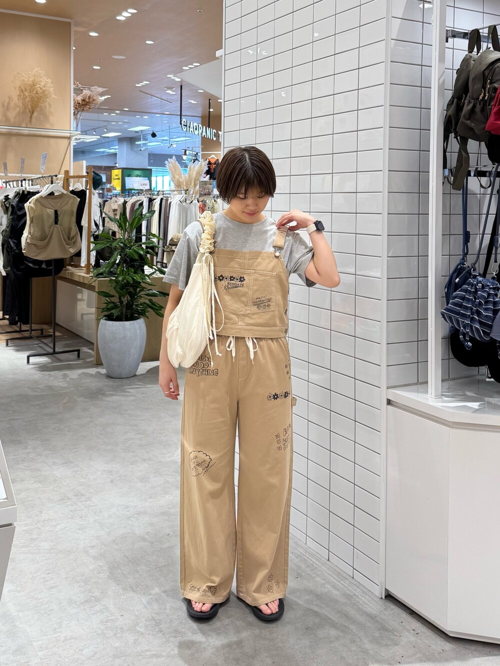 ベージュ系のサロペット/オーバーオール、ホワイト系のTシャツ/カットソー、ホワイト系のトートバッグを着用したレディースの夏コーディネートの4枚目の写真