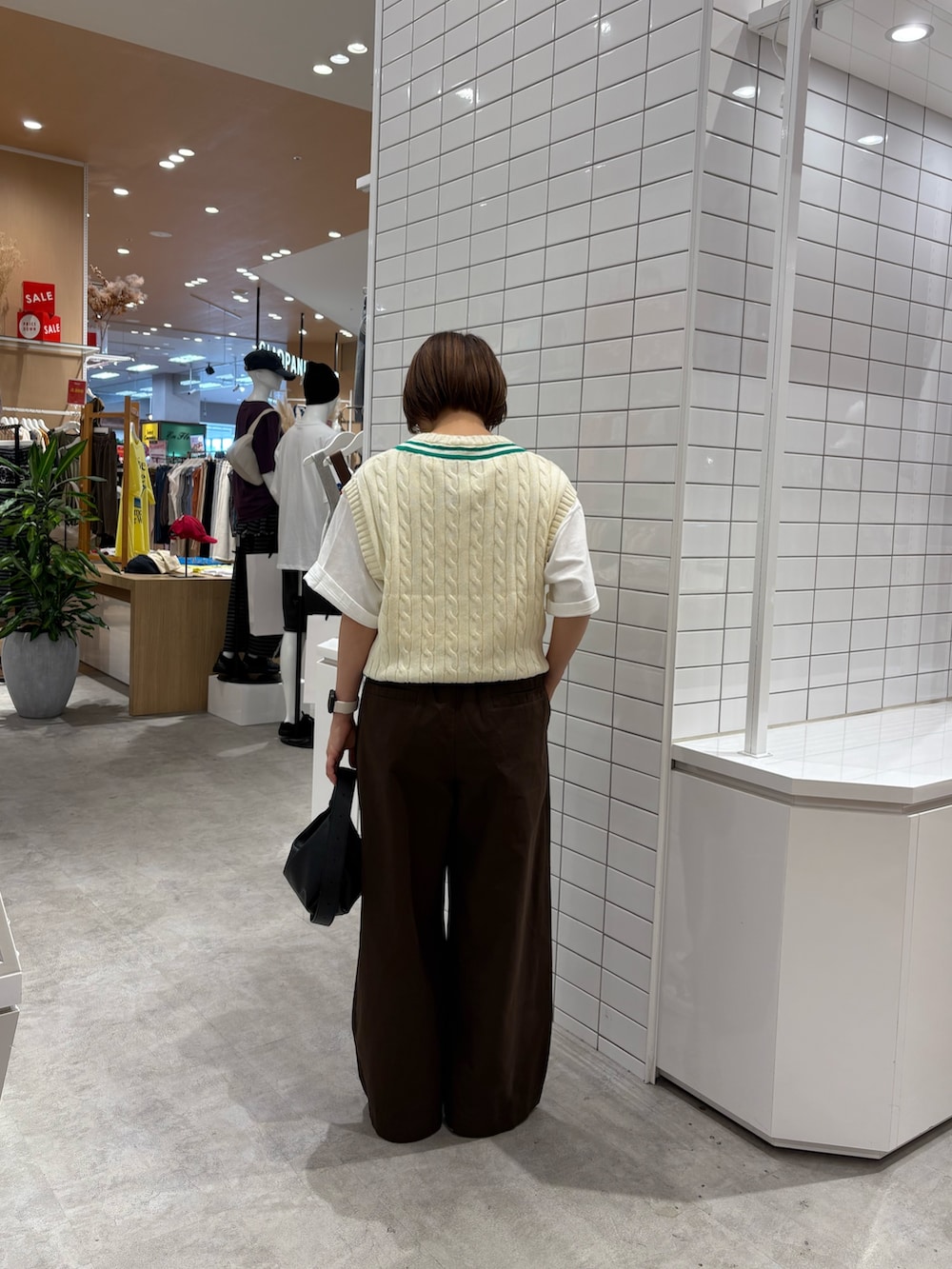 ホワイト系のTシャツ/カットソー、ホワイト系のベスト、ブラウン系のデニムパンツを着用したレディースの秋コーディネートの4枚目の写真