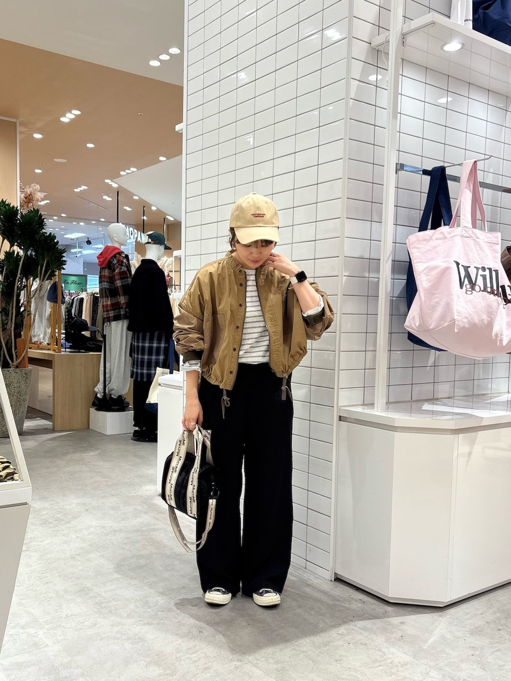 イエロー系のブルゾン、グレー系のTシャツ/カットソー、ブラック系のショルダーバッグを着用したレディースの秋コーディネートの2枚目の写真