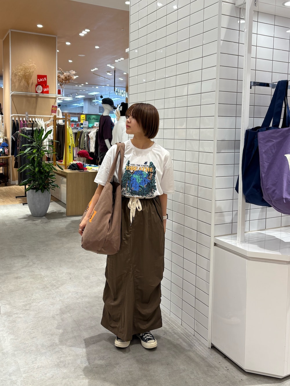 ホワイト系のTシャツ/カットソー、ブラウン系のスカート、ブラウン系のトートバッグを着用したレディースの秋コーディネートの3枚目の写真