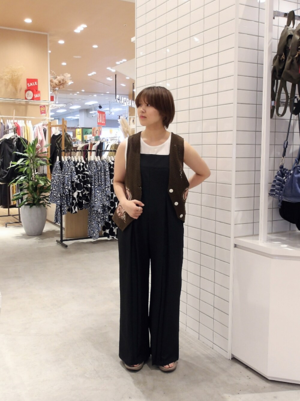ブラック系のサロペット/オーバーオール、ブラウン系のベストを着用したレディースの夏コーディネートの2枚目の写真