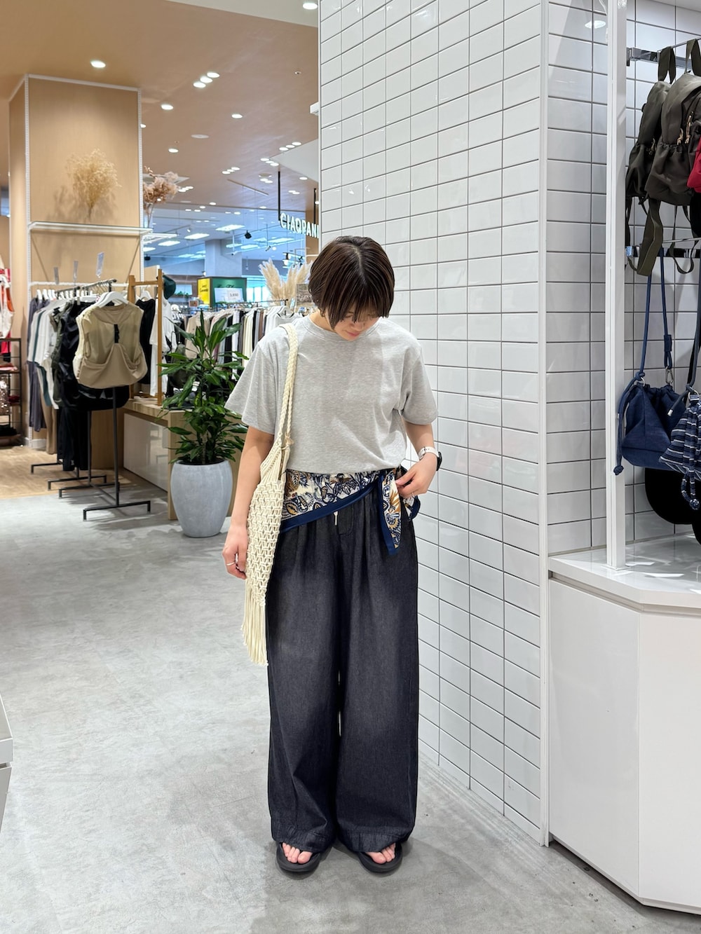 ホワイト系のTシャツ/カットソー、ブラック系のデニムパンツ、ホワイト系のトートバッグを着用したレディースの夏コーディネートの3枚目の写真