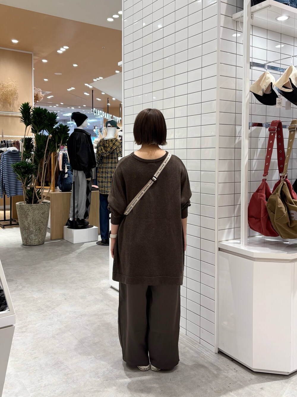 ホワイト系のショルダーバッグ、ブラウン系のニット/セーター、グレー系のその他パンツを着用したレディースの秋コーディネートの4枚目の写真