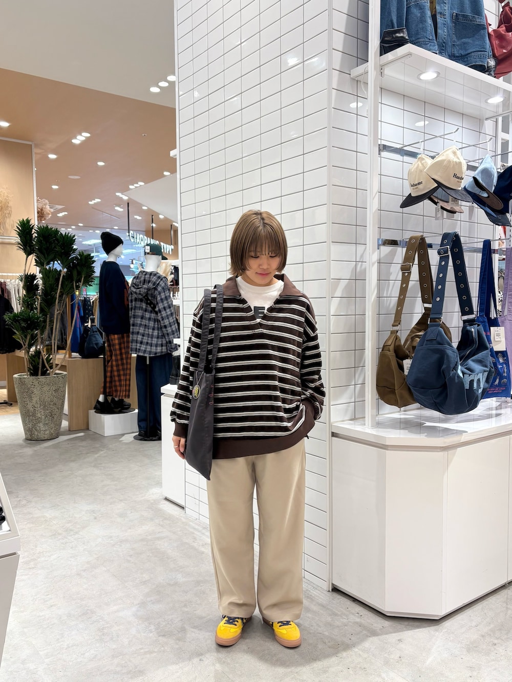 ブラウン系のTシャツ/カットソー、ベージュ系のスラックス、ブラック系のトートバッグを着用したレディースの秋コーディネートの2枚目の写真