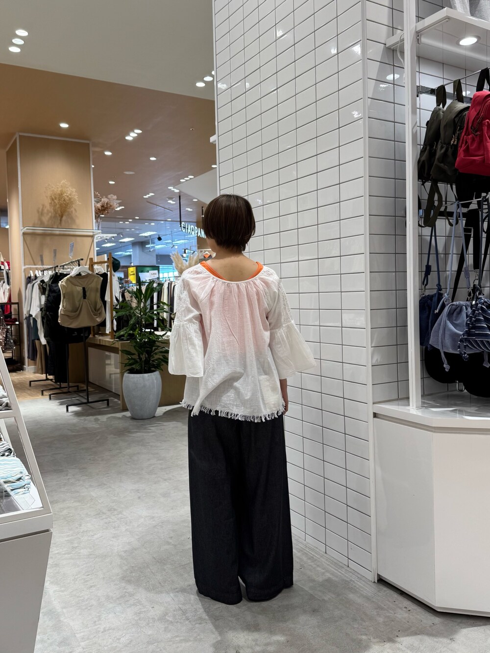 ホワイト系のシャツ/ブラウス、オレンジ系のタンクトップ、ブラック系のデニムパンツを着用したレディースの夏コーディネートの4枚目の写真