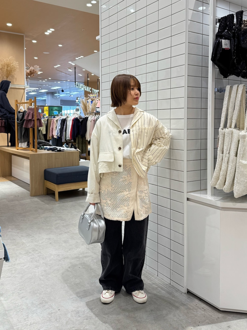 ホワイト系のTシャツ/カットソー、ホワイト系のスカート、ブラック系のデニムパンツを着用したレディースの春コーディネートの2枚目の写真