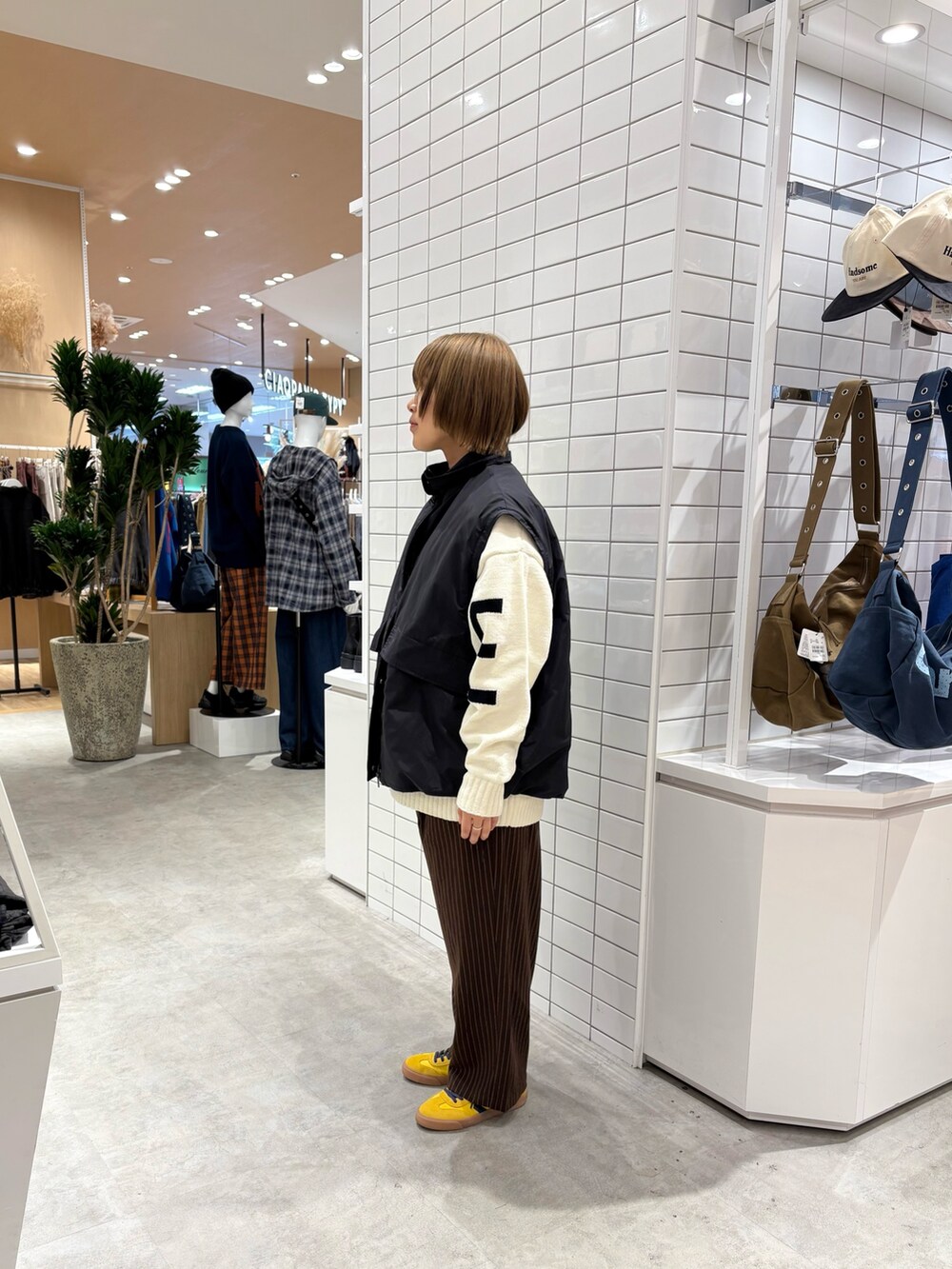 ホワイト系のニット/セーター、ブラウン系のスラックス、ブラック系のブルゾンを着用したレディースの秋コーディネートの4枚目の写真