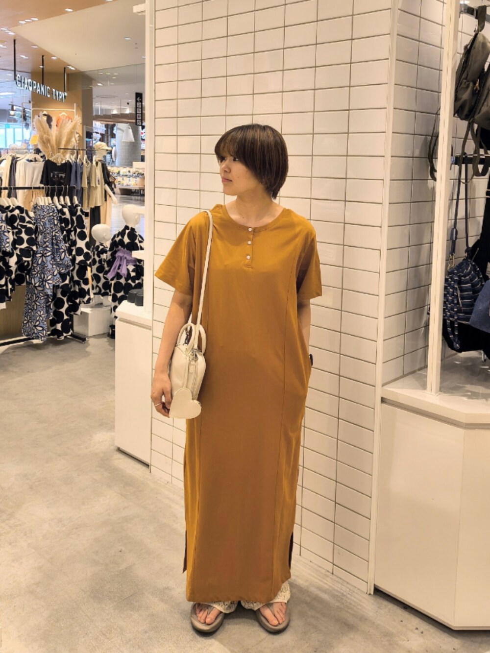 イエロー系のワンピース、ホワイト系のその他パンツ、ホワイト系のトートバッグを着用したレディースの夏コーディネートの3枚目の写真